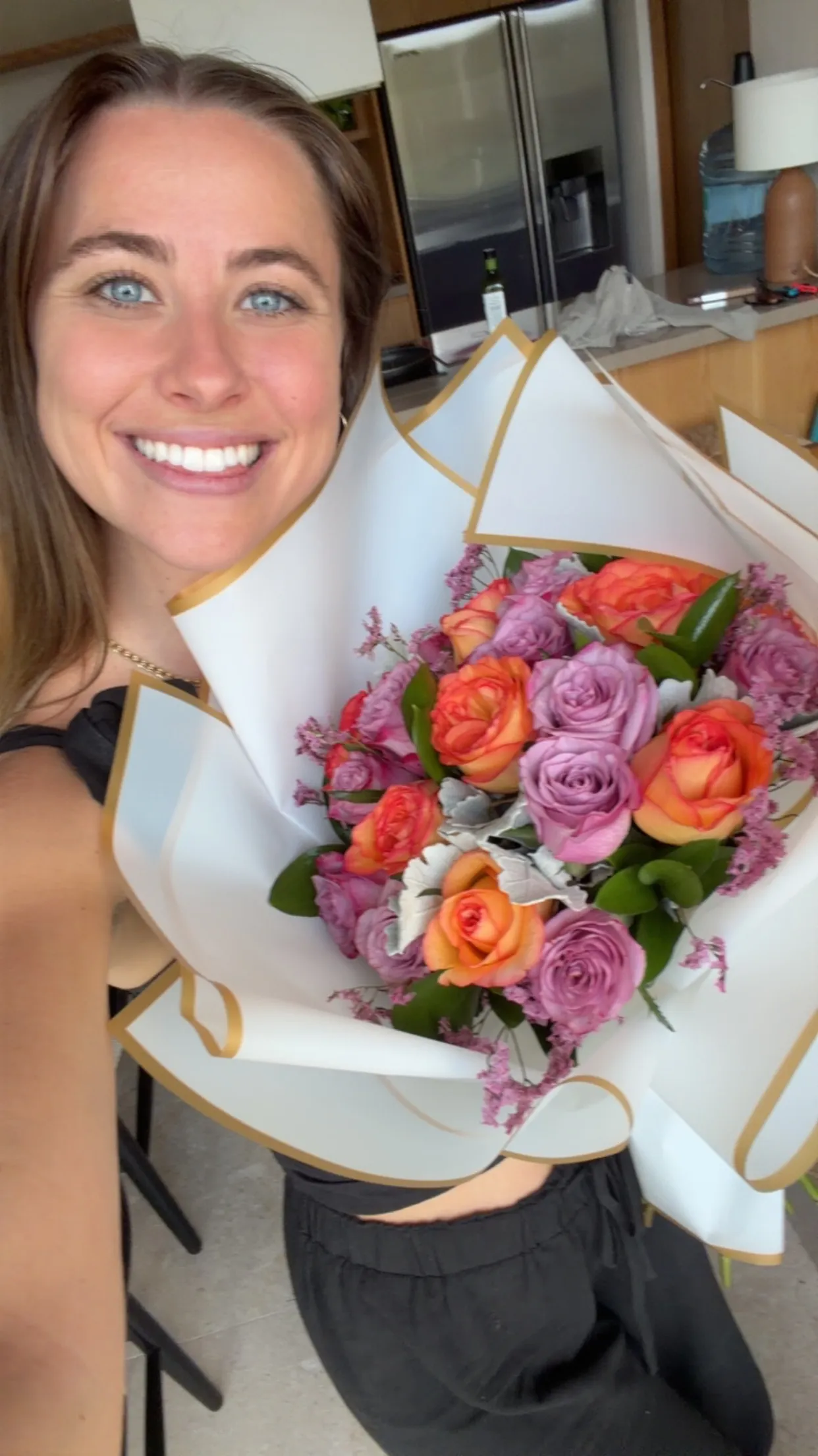Lana smiling with a beautiful bouquet of roses